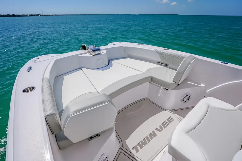 Slide: The Image of 2026 Twin Vee 240 GFX CC boat interior with white seating, on calm blue water. - 29