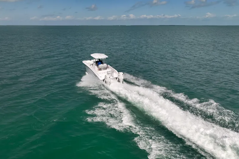 Slide: The Image of Twin Vee 240 GFX CC 2026 cruising on open ocean, leaving a white wake trail. - 33