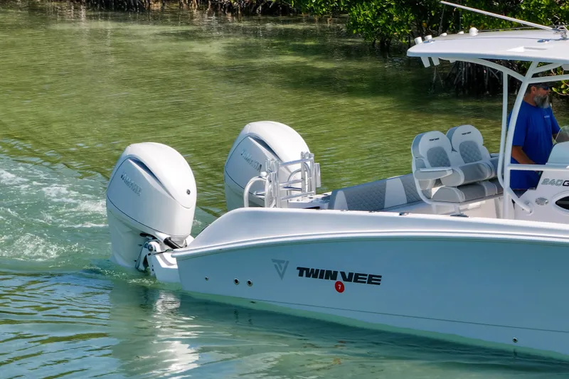 Slide: The Image of 2026 Twin Vee 240 GFX CC boat cruising in clear water with dual engines. - 43