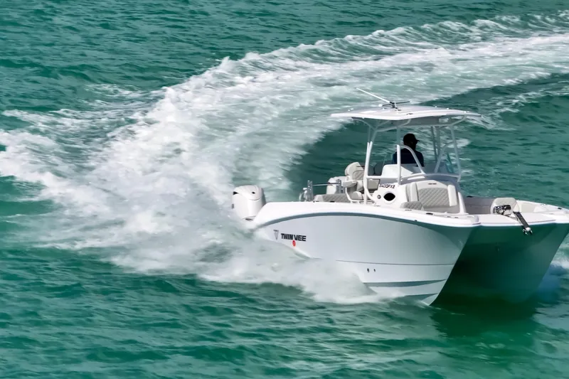 Slide: The Image of 2026 Twin Vee 240 GFX CC boat cruising on turquoise water, creating a dynamic wake. - 9