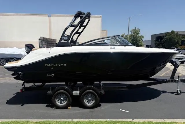 The Image of 2026 Bayliner V20i boat on trailer, sleek black design, parked outdoors. - 0