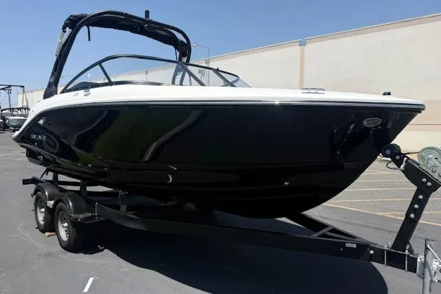 Slide: The Image of 2026 Bayliner V20i boat on trailer, sleek black design, parked outdoors. - 1