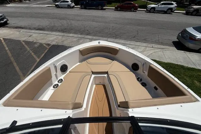 Slide: The Image of 2026 Bayliner V20i boat with spacious beige seating and sleek design, parked on street. - 14