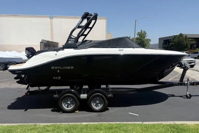 Slide: The Image of 2026 Bayliner V20i boat on trailer, sleek black and white design, parked outdoors. - 17