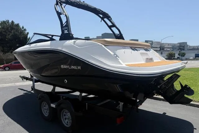 Slide: The Image of 2026 Bayliner V20i boat on trailer, sleek design, black and white exterior. - 2