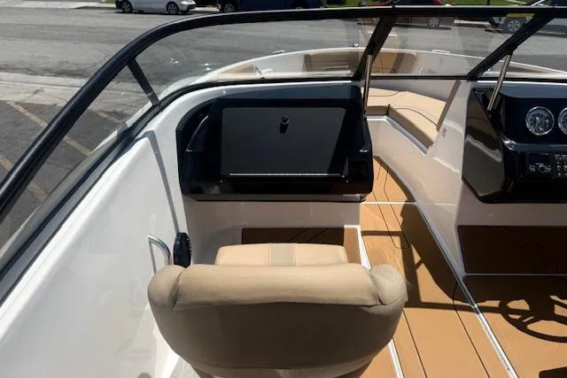 Slide: The Image of 2026 Bayliner V20i boat interior with beige seating and sleek dashboard design. - 20