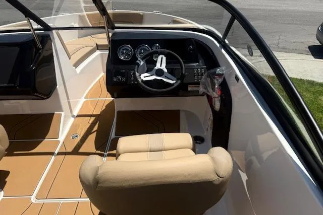 Slide: The Image of Interior view of 2026 Bayliner V20i boat with beige seating and modern dashboard. - 22