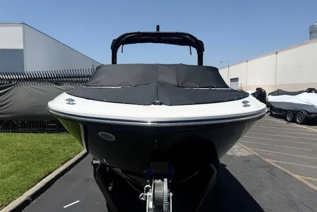 Slide: The Image of 2026 Bayliner V20i boat with black cover, parked outdoors on a sunny day. - 28