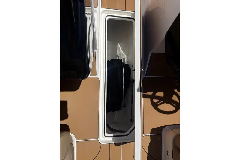Slide: The Image of 2026 Bayliner V20i boat deck with storage compartment and steering wheel. - 7