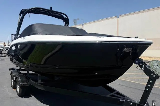 Slide: The Image of 2026 Bayliner V20i boat on trailer, sleek black design, parked outdoors. - 8