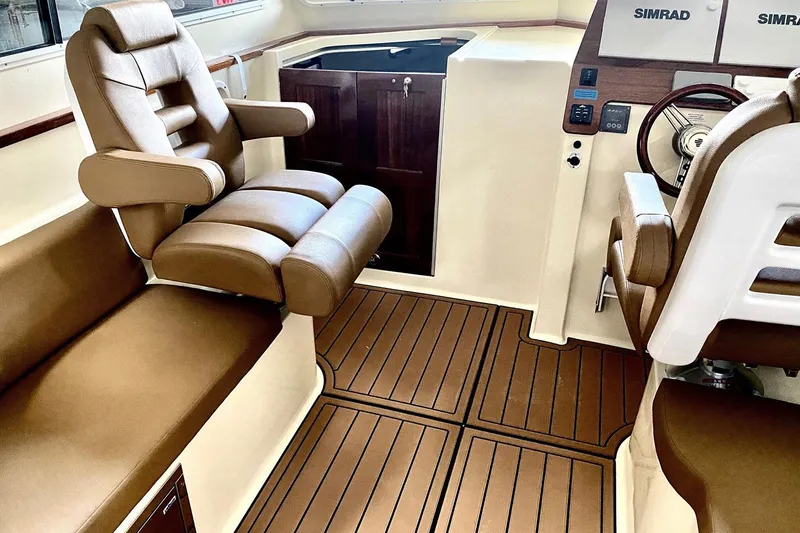 Slide: The Image of Manufacturer Provided Image: Luxurious interior of 2025 NorthCoast 315 HT boat with brown leather seating and wood flooring. - 6