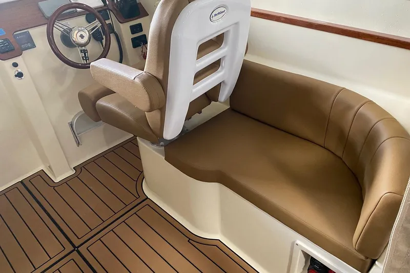 Slide: The Image of Manufacturer Provided Image: Interior of 2025 NorthCoast 315 HT boat with brown seating and wood-style flooring. - 8