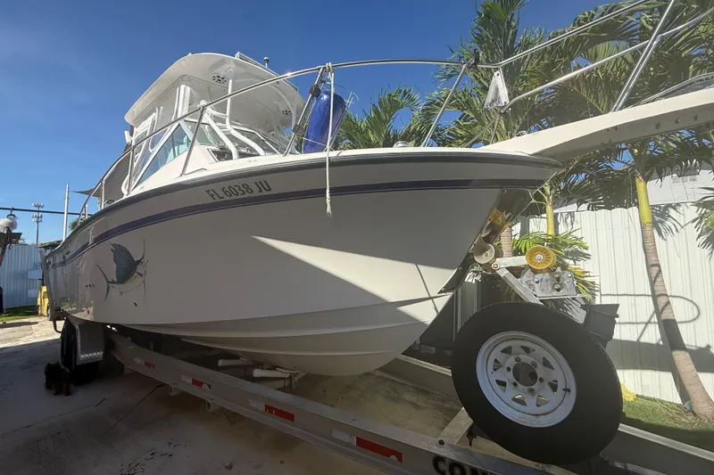 The Image of 1996 Grady-White Sailfish 272 boat on trailer, parked outdoors under clear sky. - 1