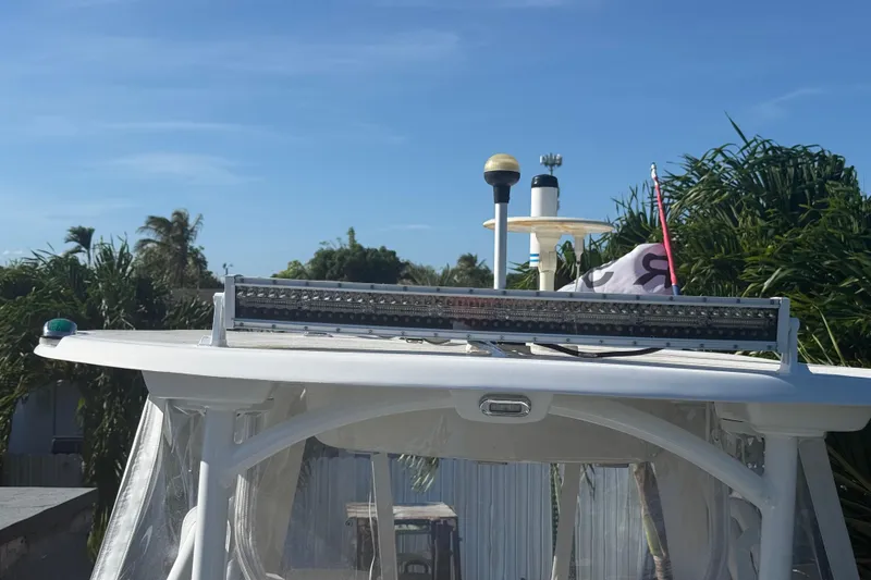 Slide: The Image of 1996 Grady-White Sailfish 272 boat with radar and antenna, set against a clear sky. - 100