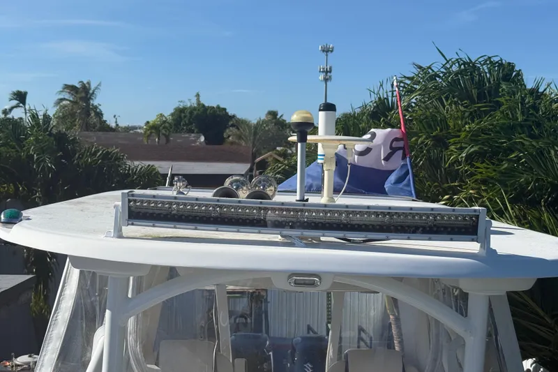 Slide: The Image of 1996 Grady-White Sailfish 272 boat with radar and antennas on top, surrounded by palm trees. - 101