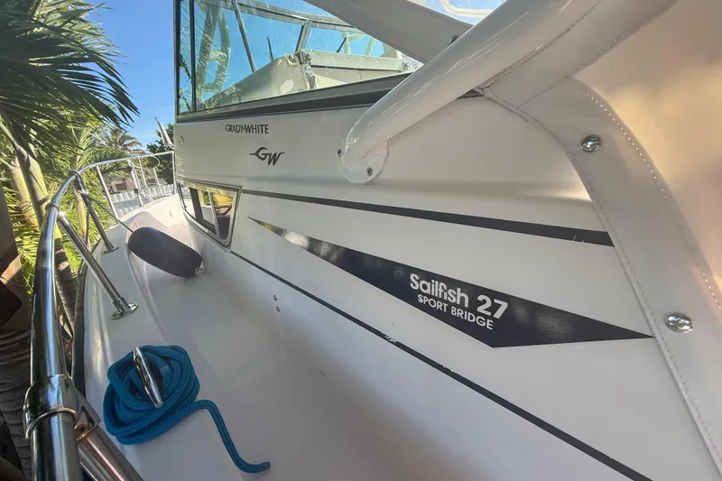 Slide: The Image of 1996 Grady-White Sailfish 272 boat with blue rope, docked near palm trees. - 107