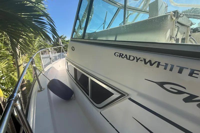 Slide: The Image of 1996 Grady-White Sailfish 272 boat docked near palm trees, side view. - 108