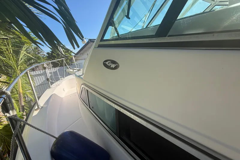 Slide: The Image of 1996 Grady-White Sailfish 272 boat docked, featuring sleek design and palm trees nearby. - 109