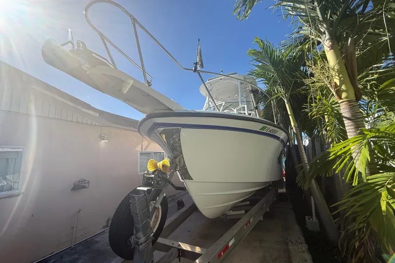 Slide: The Image of 1996 Grady-White Sailfish 272 boat on trailer, surrounded by palm trees, under clear blue sky. - 11