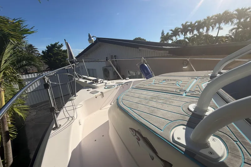 Slide: The Image of 1996 Grady-White Sailfish 272 boat deck with railing, docked near palm trees. - 111