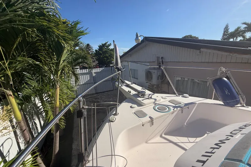 Slide: The Image of 1996 Grady-White Sailfish 272 boat docked near tropical plants and a house. - 113