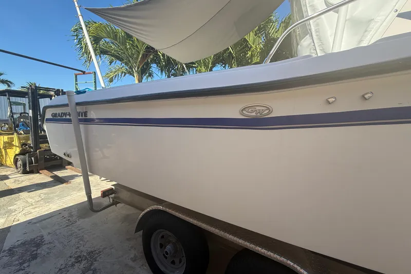 Slide: The Image of 1996 Grady-White Sailfish 272 boat on trailer, parked outdoors under palm trees. - 12