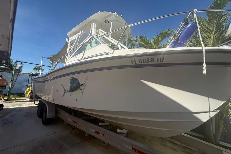 Slide: The Image of 1996 Grady-White Sailfish 272 boat on trailer, featuring sailfish graphic and registration number. - 2