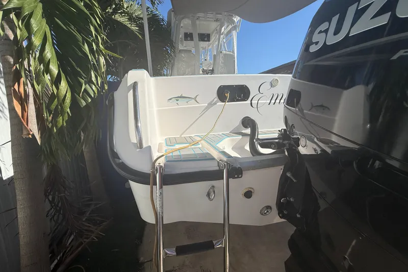 Slide: The Image of 1996 Grady-White Sailfish 272 boat with Suzuki engine, docked near palm trees. - 22