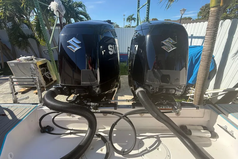 Slide: The Image of Twin Suzuki outboard motors on a 1996 Grady-White Sailfish 272 boat, docked outdoors. - 28