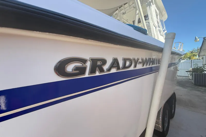 Slide: The Image of 1996 Grady-White Sailfish 272 boat with blue stripe and logo detail. - 29