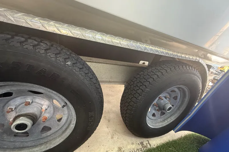 Slide: The Image of Trailer wheels of a 1996 Grady-White Sailfish 272 boat on a metal surface. - 31