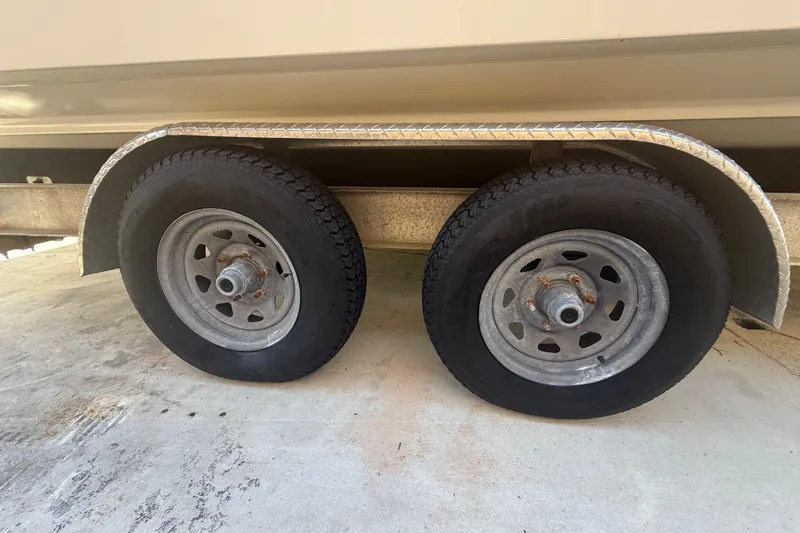 Slide: The Image of Trailer wheels of a 1996 Grady-White Sailfish 272 boat on concrete surface. - 32
