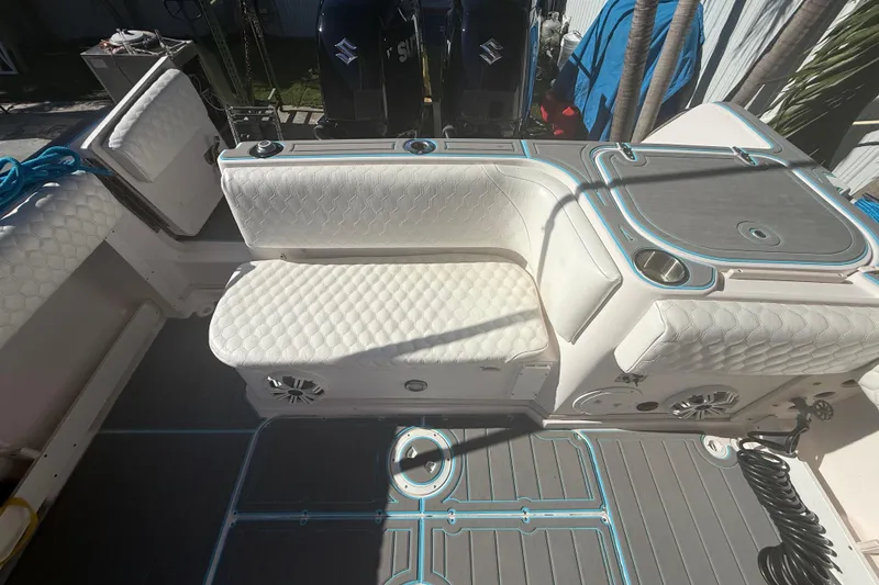 Slide: The Image of 1996 Grady-White Sailfish 272 boat interior with cushioned seating and dual Suzuki engines. - 36