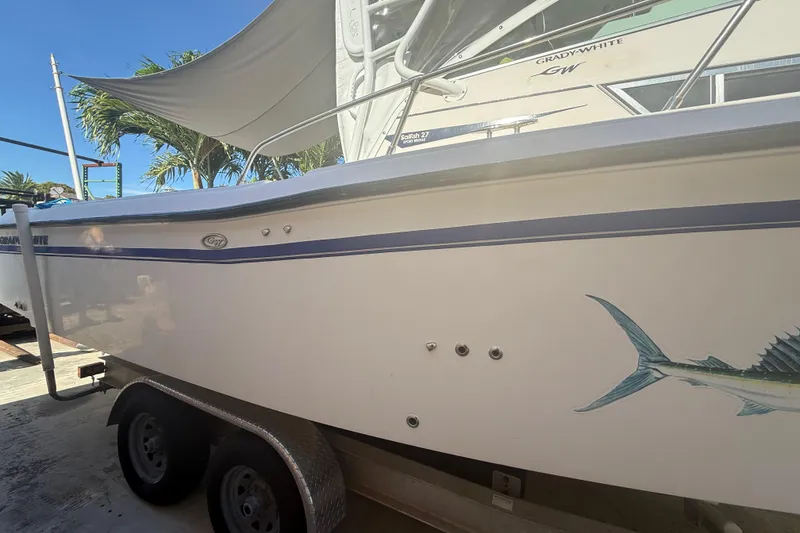 Slide: The Image of 1996 Grady-White Sailfish 272 boat on trailer, featuring marlin graphic and palm trees in background. - 4