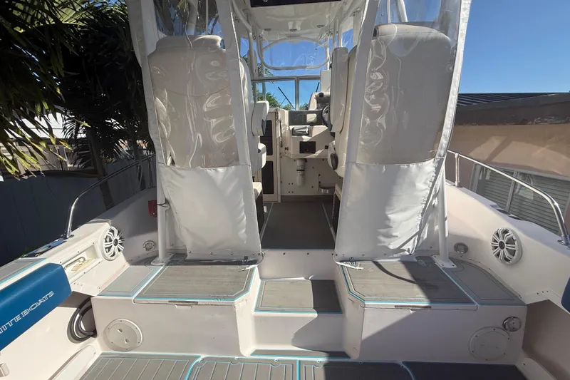 Slide: The Image of 1996 Grady-White Sailfish 272 boat interior with seating and helm, under clear blue sky. - 40