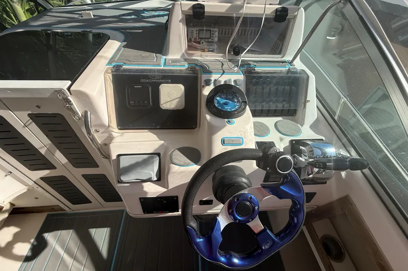 Slide: The Image of 1996 Grady-White Sailfish 272 boat cockpit with steering wheel and control panel. - 46