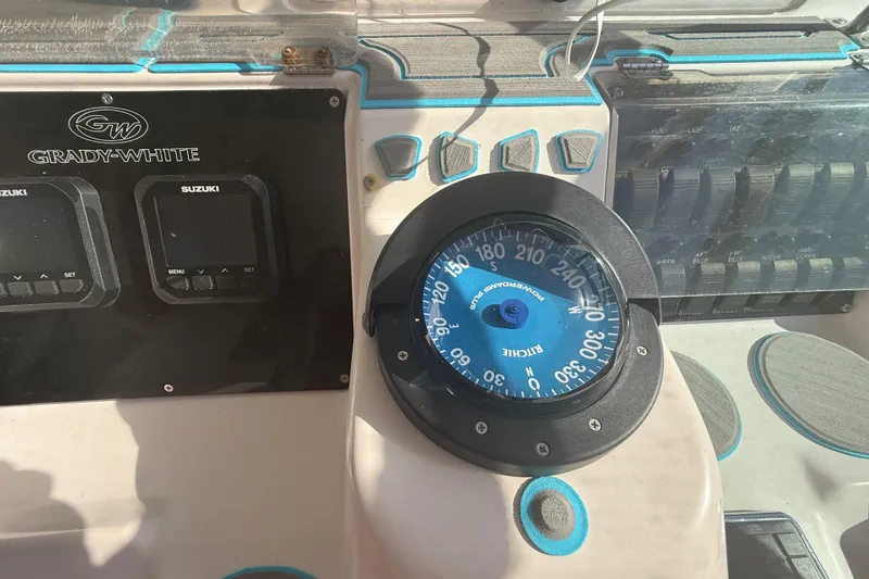 Slide: The Image of 1996 Grady-White Sailfish 272 boat dashboard with compass and Suzuki controls. - 49