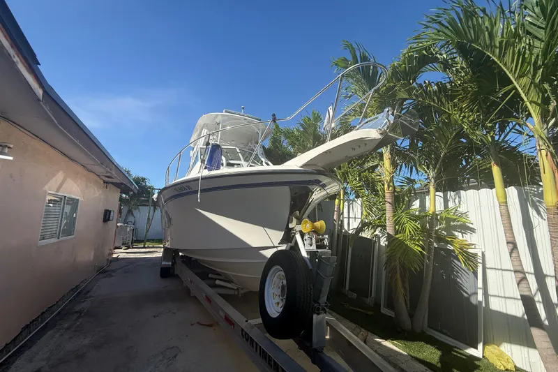 Slide: The Image of 1996 Grady-White Sailfish 272 boat on trailer, surrounded by palm trees. - 5