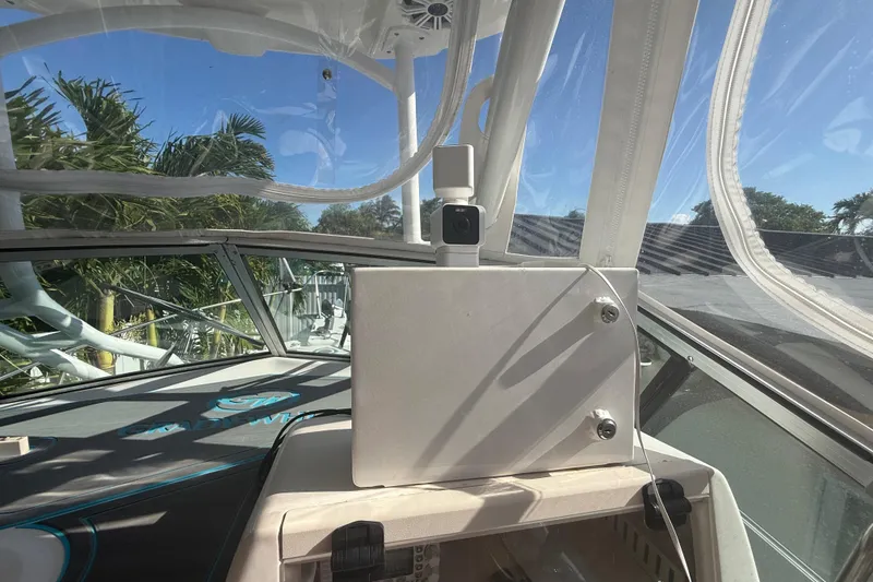 Slide: The Image of 1996 Grady-White Sailfish 272 cockpit with clear canopy and lush greenery outside. - 50