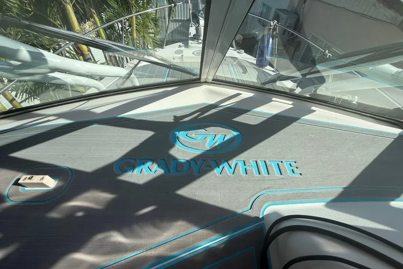 Slide: The Image of 1996 Grady-White Sailfish 272 boat deck with logo, surrounded by tropical foliage. - 54