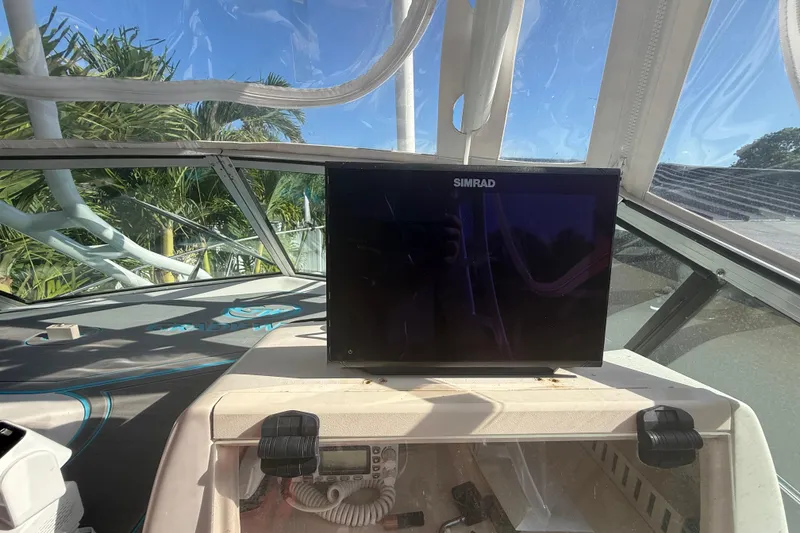 Slide: The Image of 1996 Grady-White Sailfish 272 boat interior with Simrad navigation display under clear blue sky. - 55