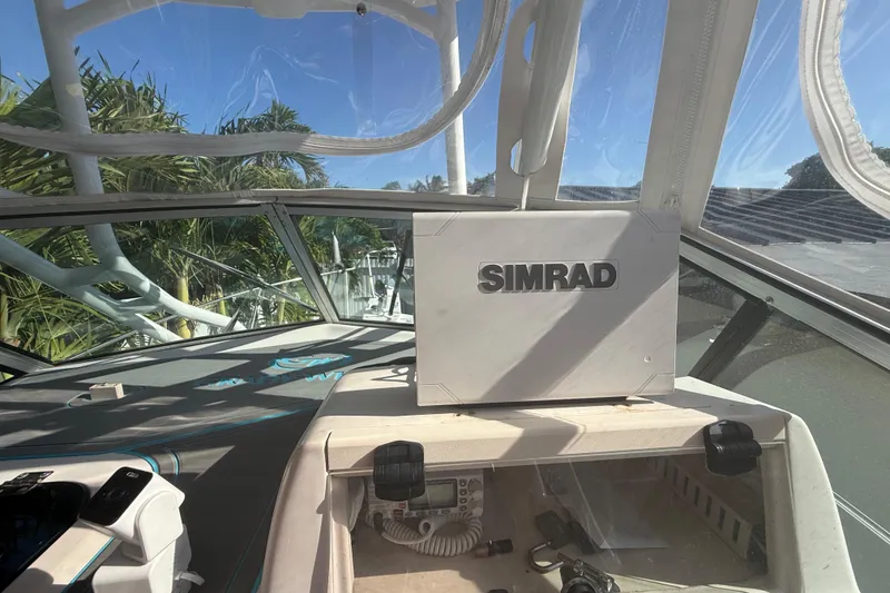 Slide: The Image of 1996 Grady-White Sailfish 272 boat cockpit with Simrad navigation system, surrounded by clear canopy. - 57