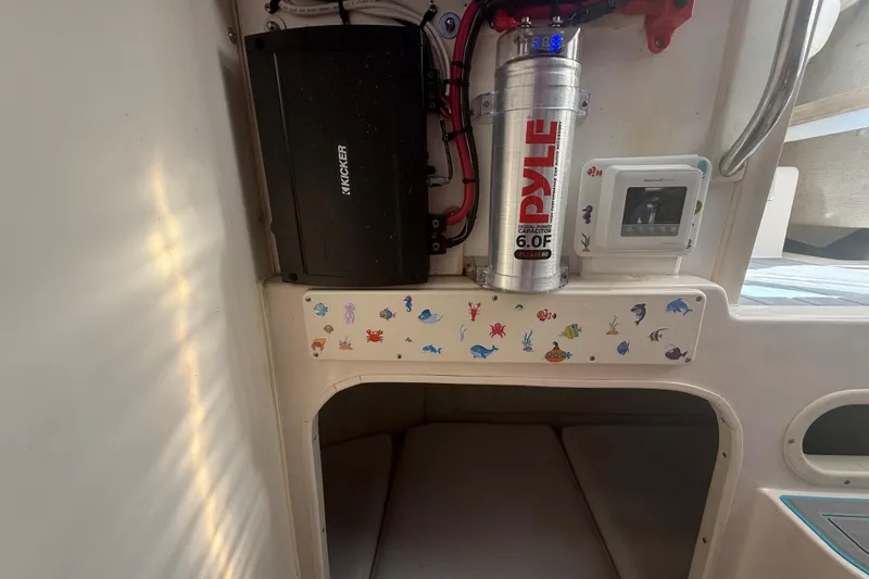 Slide: The Image of Interior of 1996 Grady-White Sailfish 272 with audio equipment and marine-themed stickers. - 59
