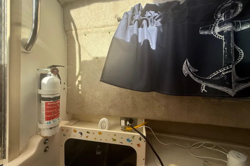 Slide: The Image of Interior of 1996 Grady-White Sailfish 272 with fire extinguisher and anchor-themed curtain. - 60