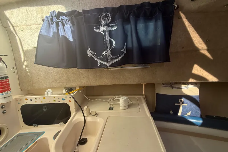 Slide: The Image of Interior of 1996 Grady-White Sailfish 272 with nautical-themed decor and anchor curtains. - 61