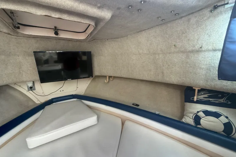 Slide: The Image of Interior cabin of 1996 Grady-White Sailfish 272 with TV and cushioned seating. - 65
