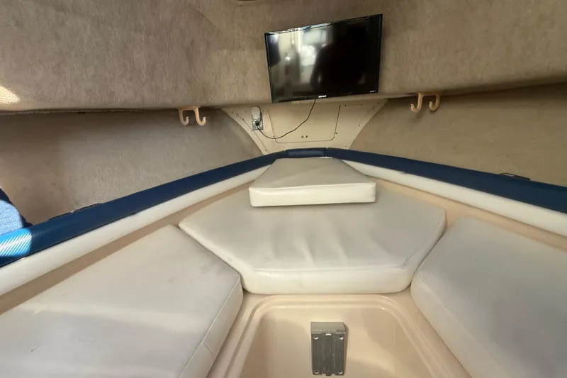 Slide: The Image of 1996 Grady-White Sailfish 272 cabin interior with cushioned seating and mounted TV. - 69