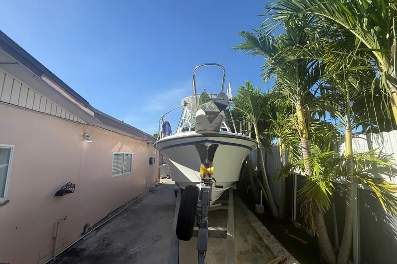 Slide: The Image of 1996 Grady-White Sailfish 272 boat on trailer, surrounded by palm trees. - 7
