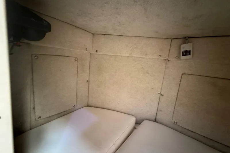 Slide: The Image of Interior cabin of 1996 Grady-White Sailfish 272 boat, featuring cushioned seating and paneling. - 72