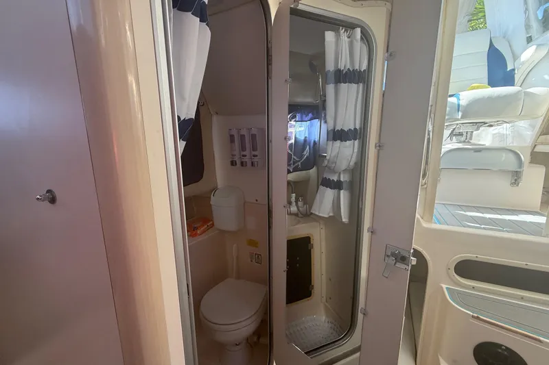 Slide: The Image of 1996 Grady-White Sailfish 272 boat interior with compact bathroom and seating area. - 82